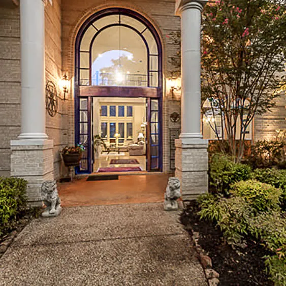 Elegant home entry photographed at twilight with warm interior lighting